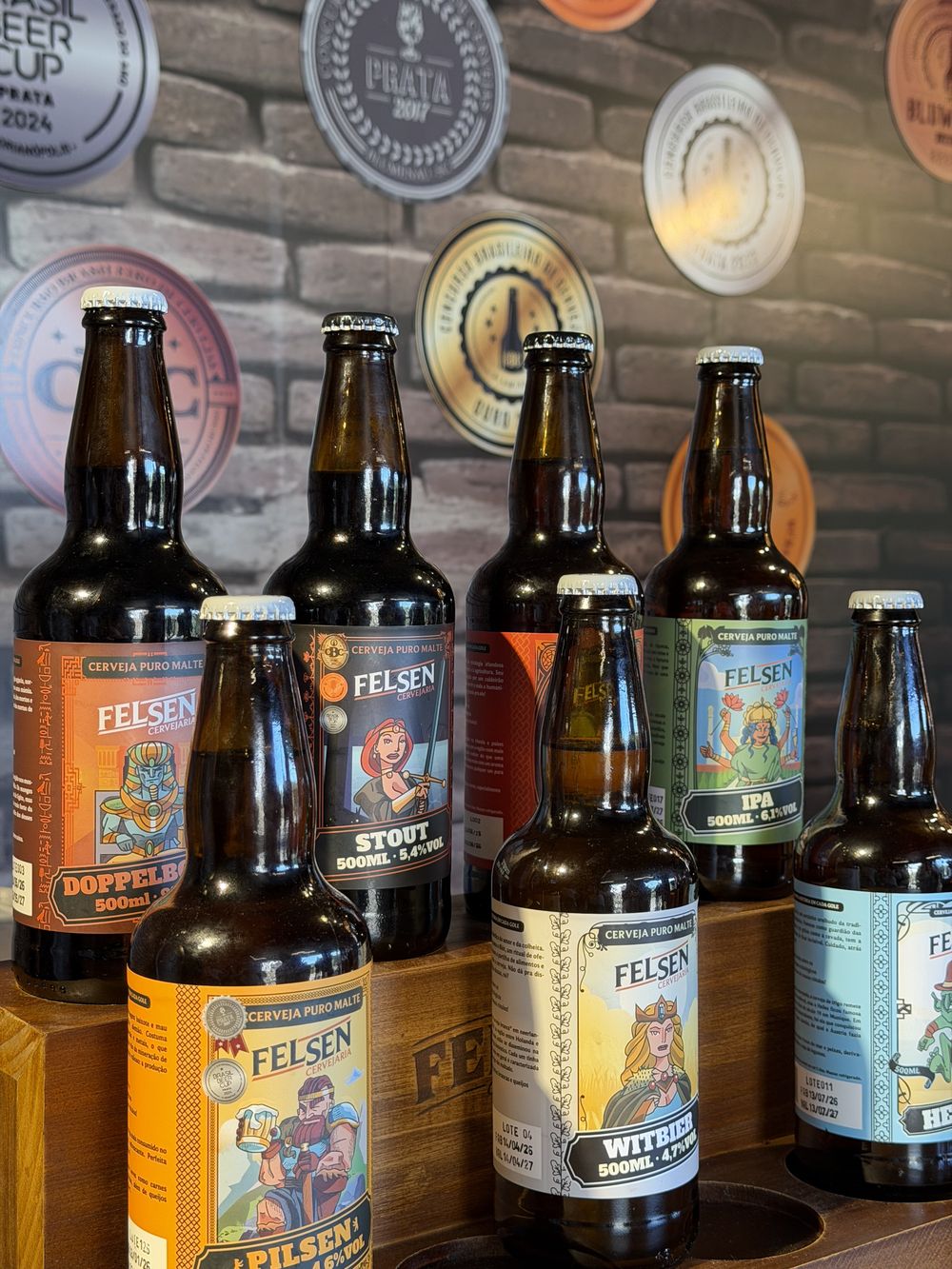Garrafas das cervejas Felsen no bar da fábrica, com medalhas na parede