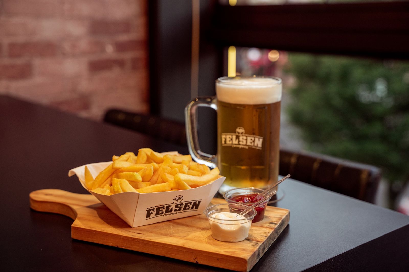 Caneca de chope Felsen e batata frita no Pub Felsen Gramado